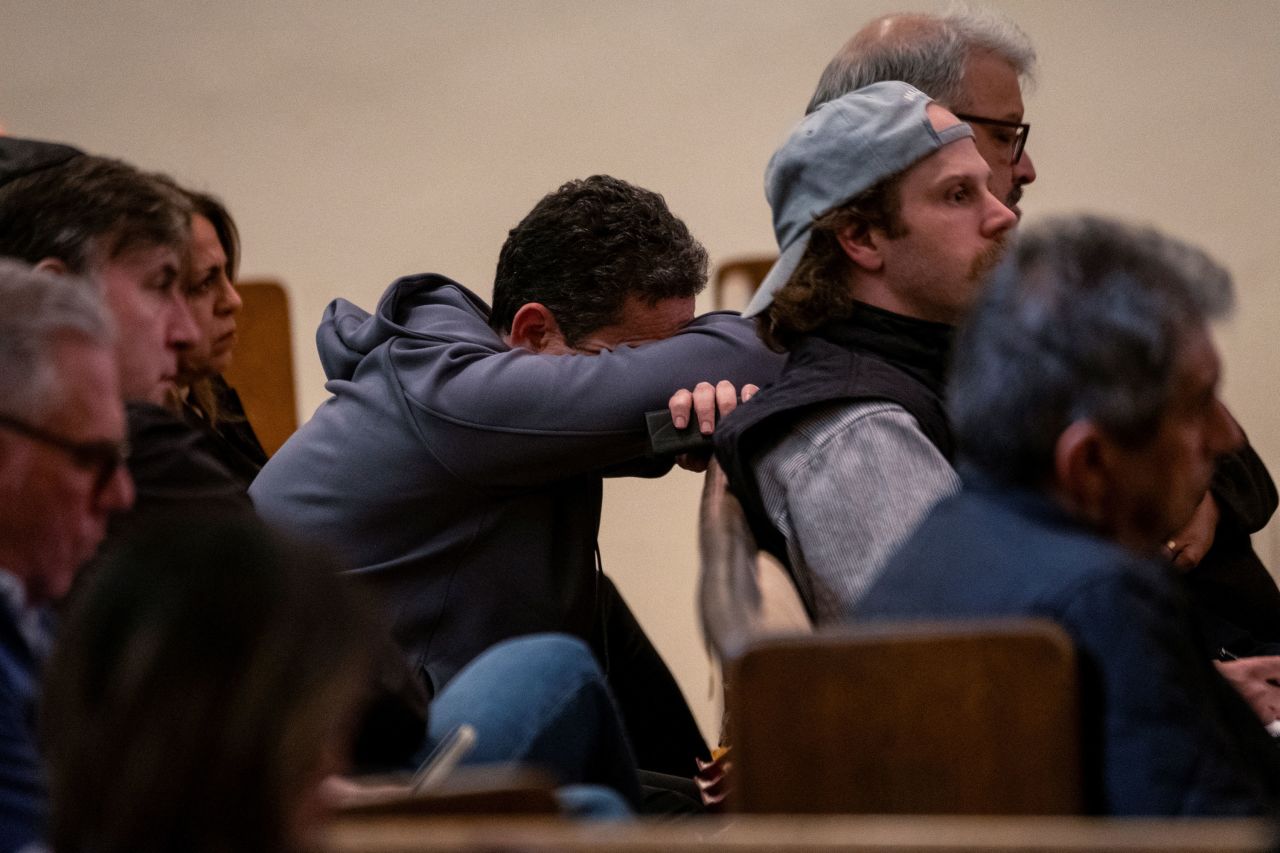 Robert Weber leans against a pew as he attends a community meeting about the Palisades Fire on Thursday at the Sinai Temple in Los Angeles.