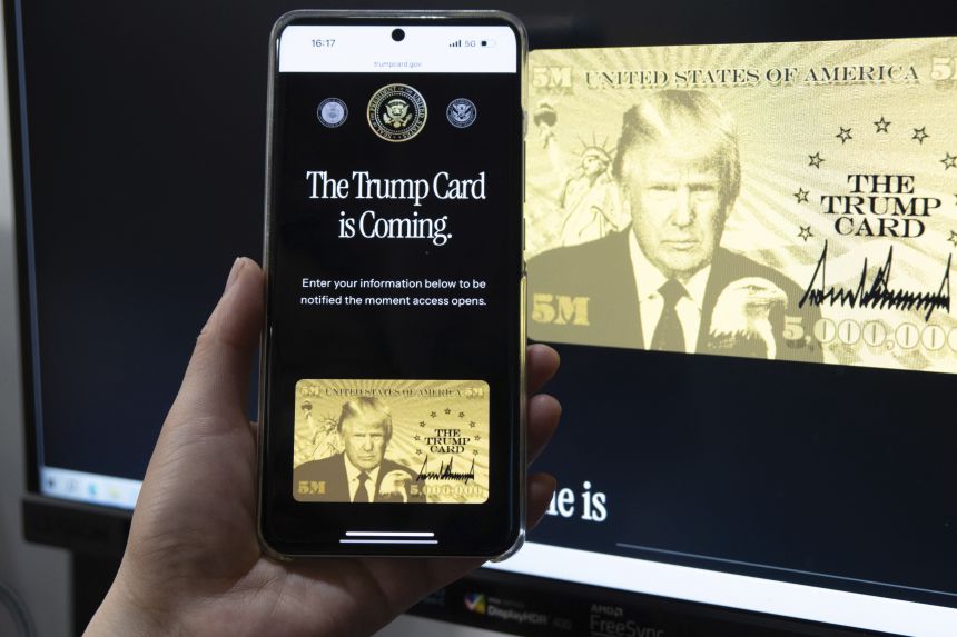 A netizen holds a smartphone displaying the website for registering interest in the new gold card visa on June 12, in Shanghai, China.