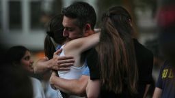 People hug while attending a vigil at Bryant Park for the people killed by a gunman at a Manhattan office building the day before, Tuesday, July 29, 2025, in New York. (AP Photo/Angelina Katsanis)