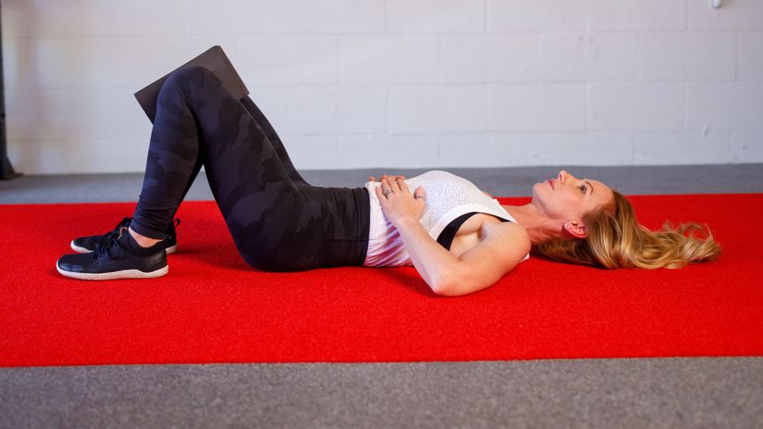 Assess your breathing by lying on your back with your knees bent and feet on the floor.