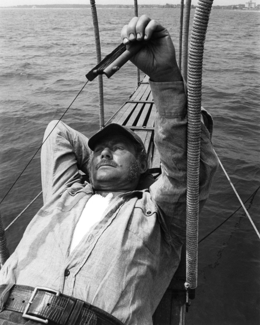 Shaw, who plays the gruff, shark-hating veteran Quint, lies on the stern of the Orca, Quint's boat. The veteran actor's troubles during the film's production were documented in the play "The Shark is Broken," written by his son Ian.