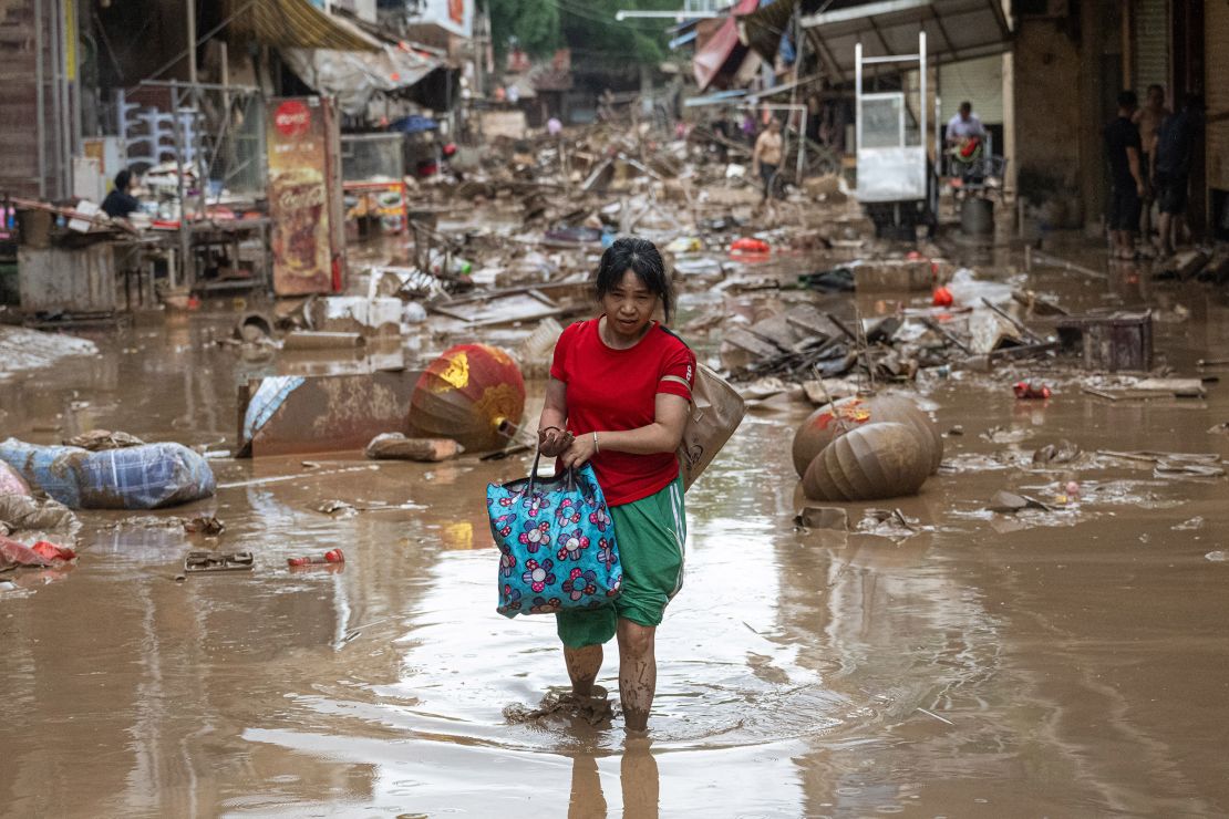 A woman walks through devastated streets in Meizhou, Guangzhou province on June 19.