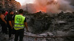 People and rescuers gather near the smouldering rubble of a building destroyed in an Israeli air strike in the Haret Hreik neighbourhood of Beirut's southern suburbs on September 27, 2024. (Photo by Ibrahim AMRO / AFP) (Photo by IBRAHIM AMRO/AFP via Getty Images)