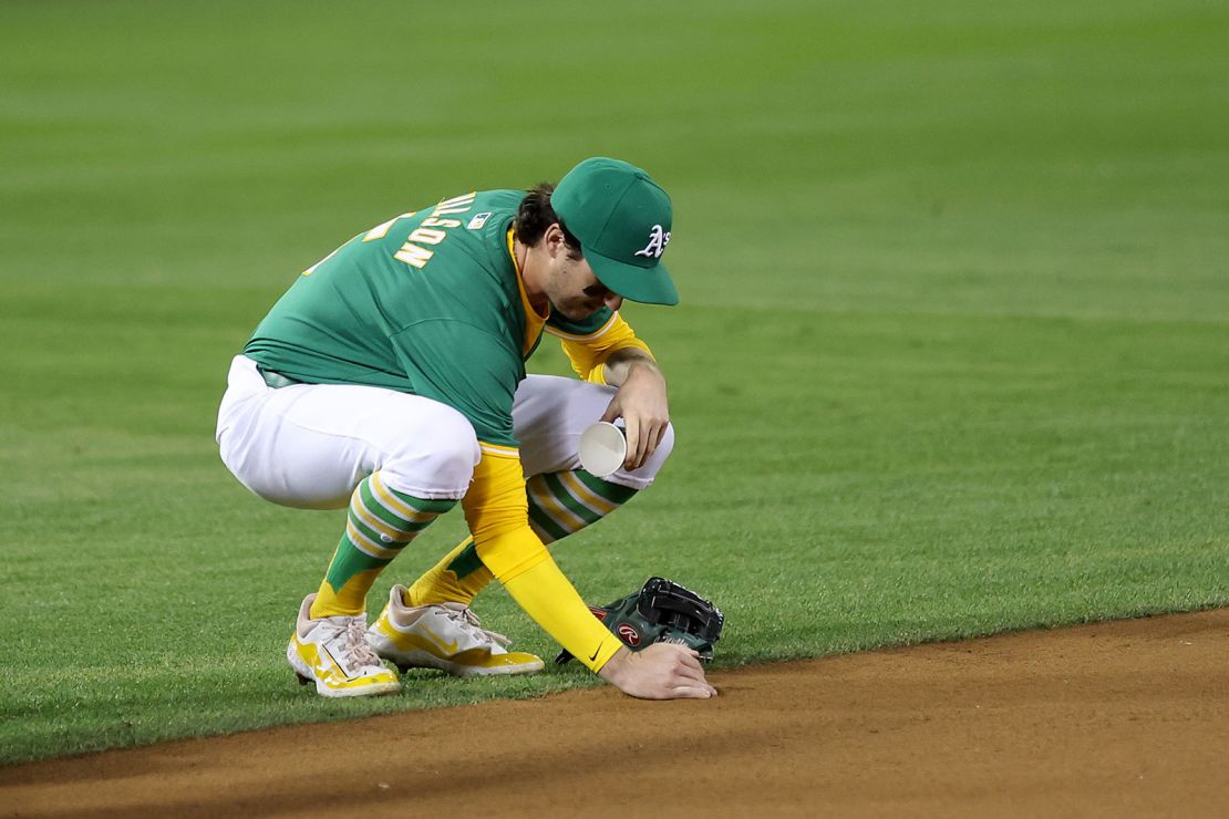 Oakland A's Jacob Wilson collects dirt from the field after the final game at Oakland Coliseum