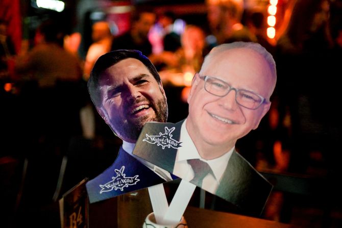 Cutout images of Vance and Walz are displayed at a debate watch party in New York.