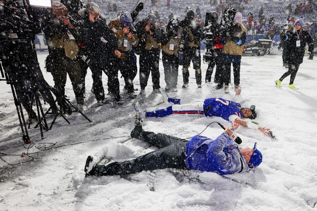 Josh Allen and head coach Sean McDermott make snow angels while being interviewed after the Bills defeated the San Francisco 49ers.