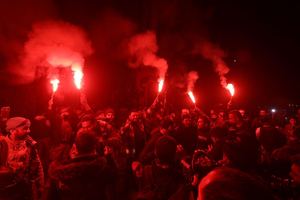 Rebel fighters and locals celebrate in Homs.