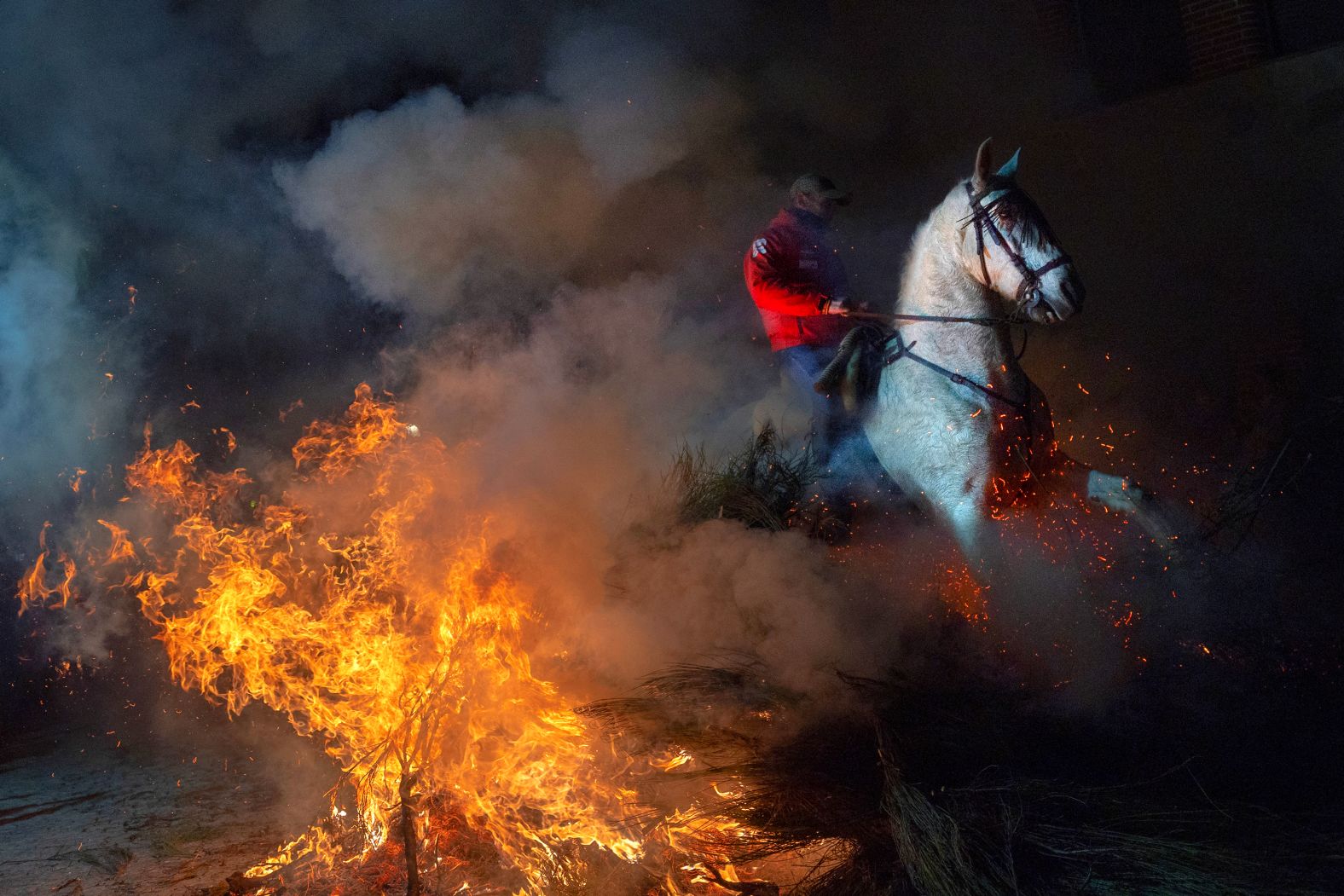 A horseman rides through a bonfire during the Las Luminarias festival in San Bartolomé de Pinares, Spain, on Thursday, January 16. The festival celebrates St. Anthony, Spain's patron saint of animals.