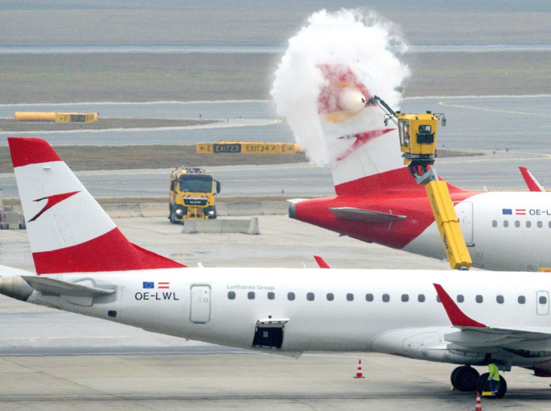 A ground crew deices a passenger plane at Vienna International Airport in February 2025.