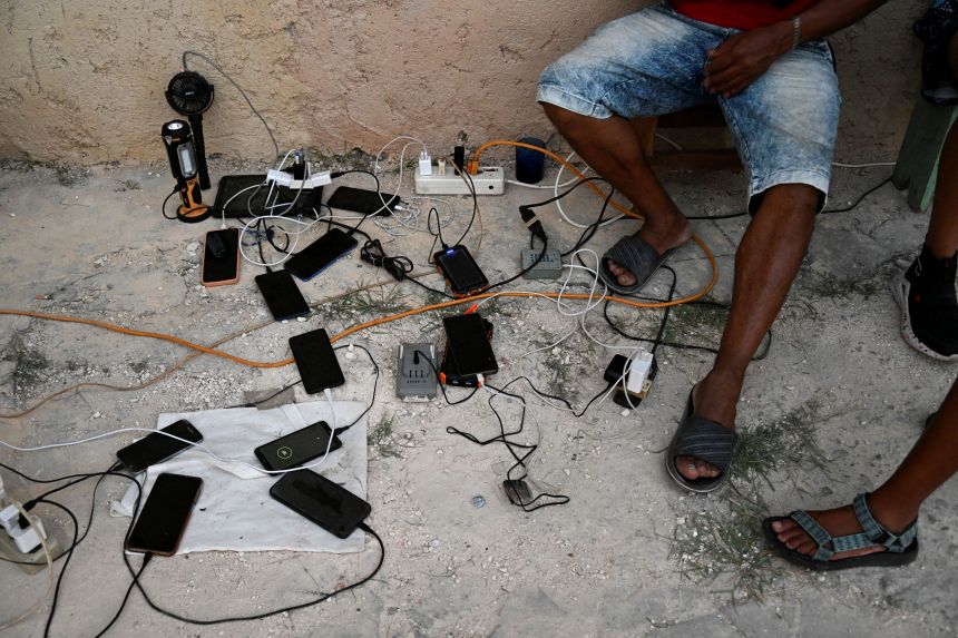 People charge cell phones during a nationwide blackout in Havana in March.