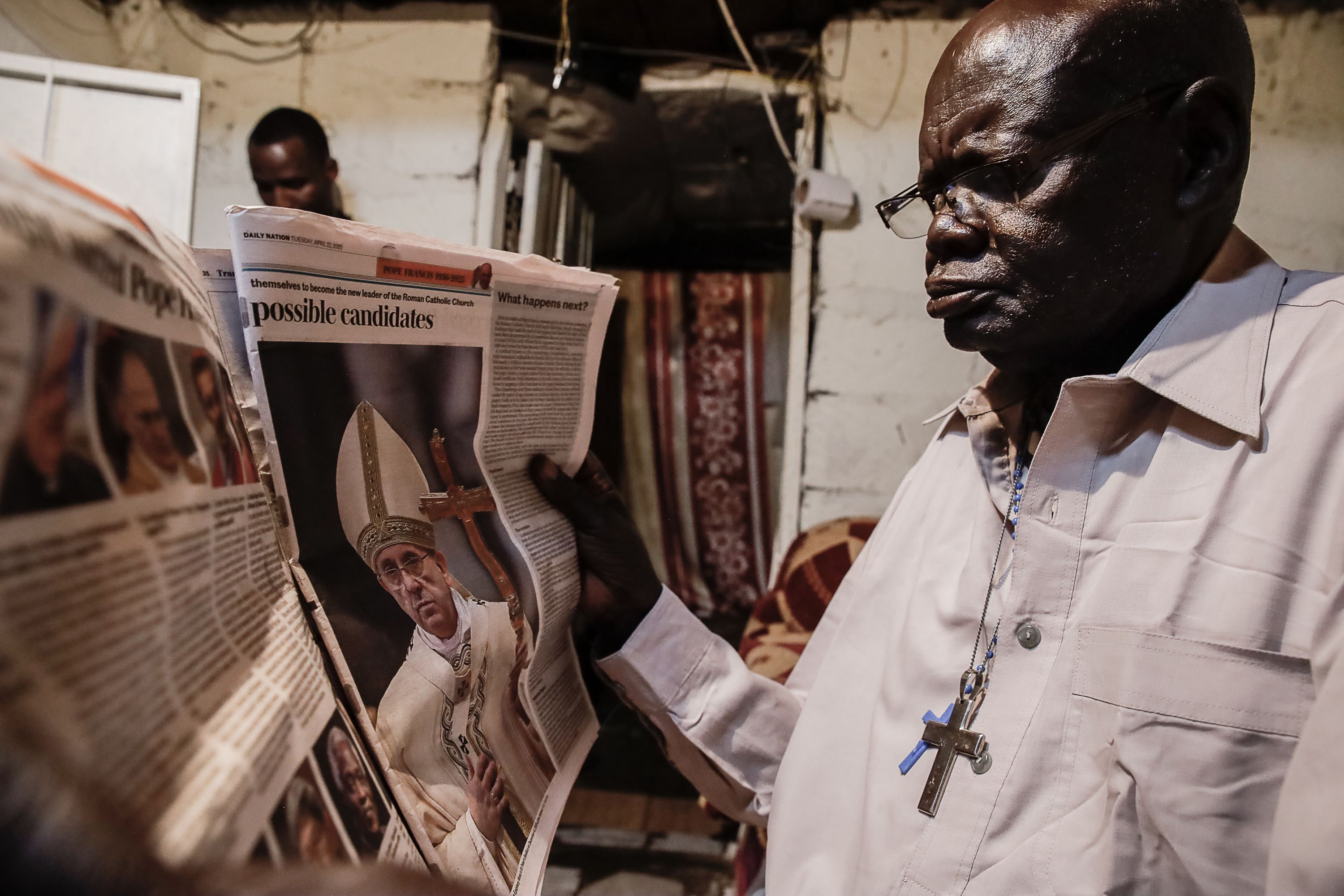 A man reads news about the pope at his home in Nairobi, Kenya.