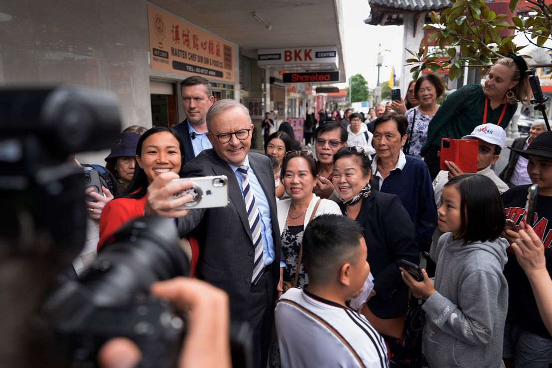 Australian Prime Minister Anthony Albanese and Labor Candidate Tu Le take a selfie with members of the public during a visit to Freedom Plaza in the electorate of Fowler in Sydney, Australia, on April 28.