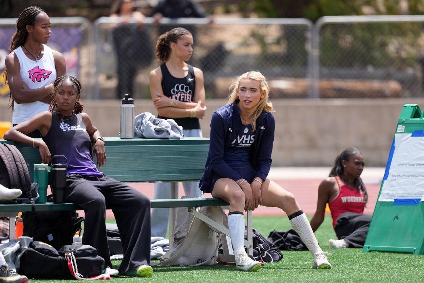 A.B. Hernandez sits on a bench at a meet.