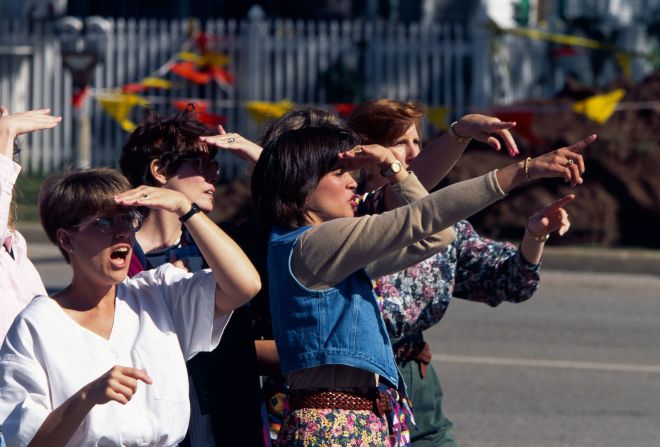 People stare in shock at the site of the destroyed building.