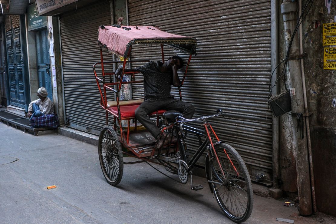 A man rests on a cycle rickshaw during a heat wave in New Delhi on April 21, 2024.