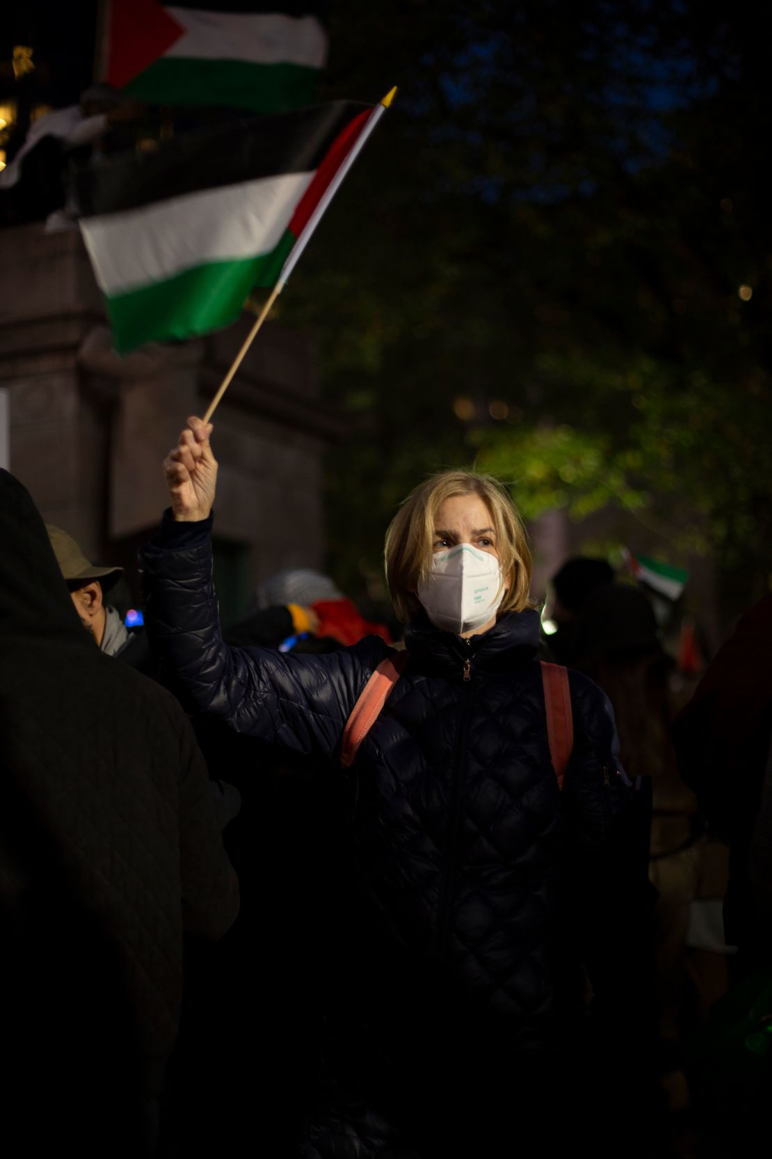 Elizabeth Oram waves a Palestinian flag during Friday night's rally. She is a supporter of Palestinian rights.