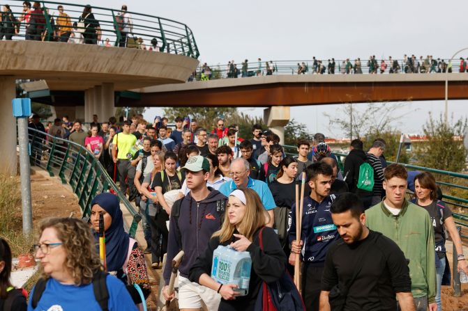 Hundreds of volunteers walk toward the town of La Torre to help people affected by the floods on Friday.