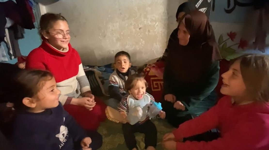 Um Ihab (second right) plays with her grandchildren on the floor of their tent. They were forced to flee after Israel’s bombardment struck their home in Jabalya, in northern Gaza last year.