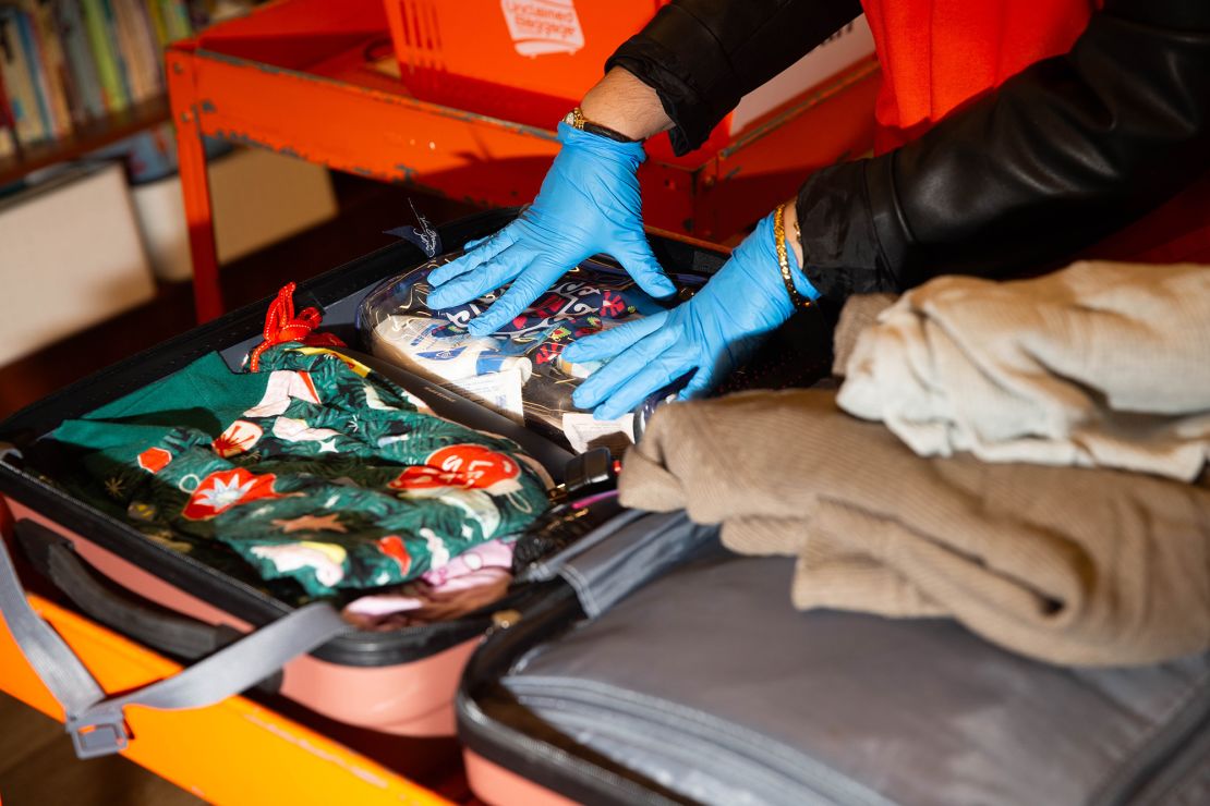 Sonni Hood, senior manager of communications at Unclaimed Baggage, shows how items in lost suitcases are inspected and divided into different categories.