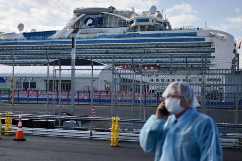 A man in protective gear speaks on a phone near the quarantined Diamond Princess cruise ship in Yokohama, Japan on \Wednesday. 