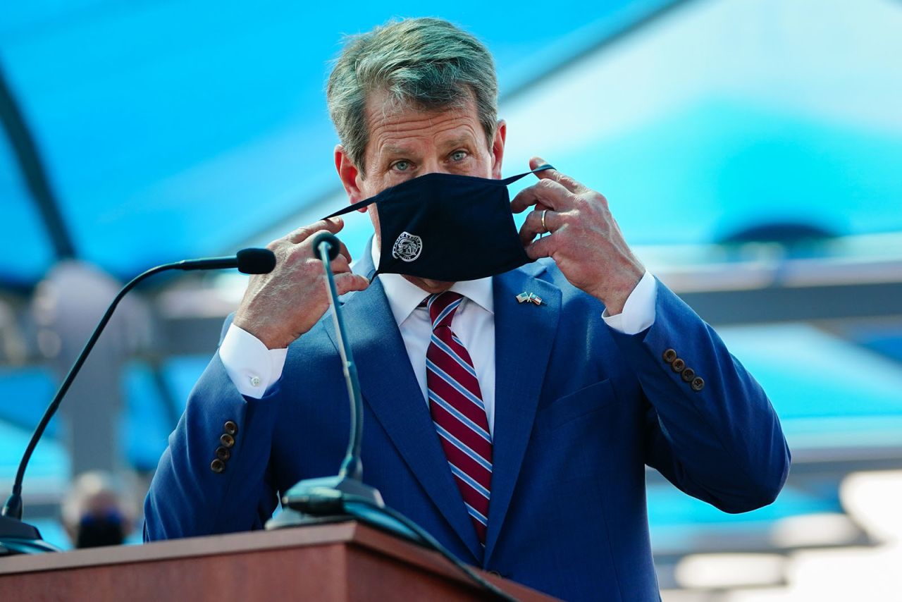 Georgia Governor Brian Kemp puts on a mask after speaking at a press conference announcing statewide expanded COVID testing on August 10, in Atlanta. 