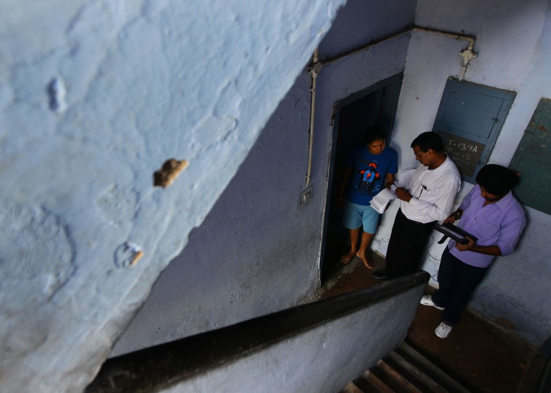 A resident in Chandgrah, India, is interviewed by an enumerator at her front door in 2011.