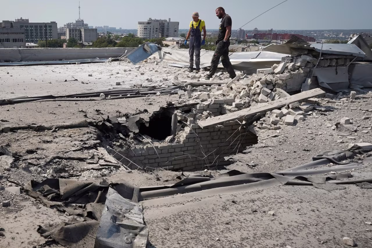 Communal employees work on a roof after it was damaged during a Russian attack in Kharkiv, Ukraine on August 30.
