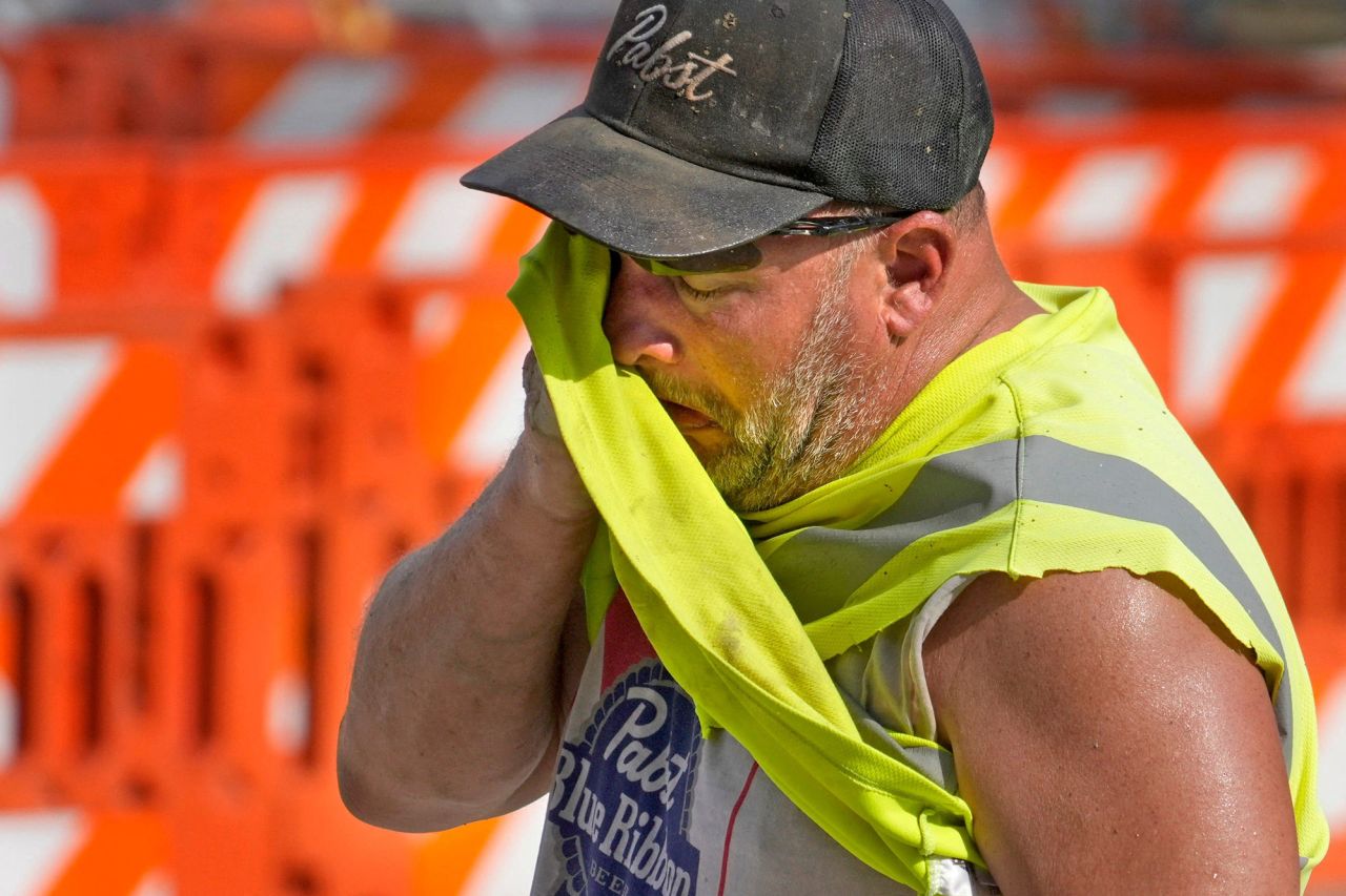 Jeff Nerby, with Arrow-Crete Construction, wipes away the sweat on a hot and humid day while working on a project in North Milwaukee Street in Milwaukee, Wisconsin, on June 17.