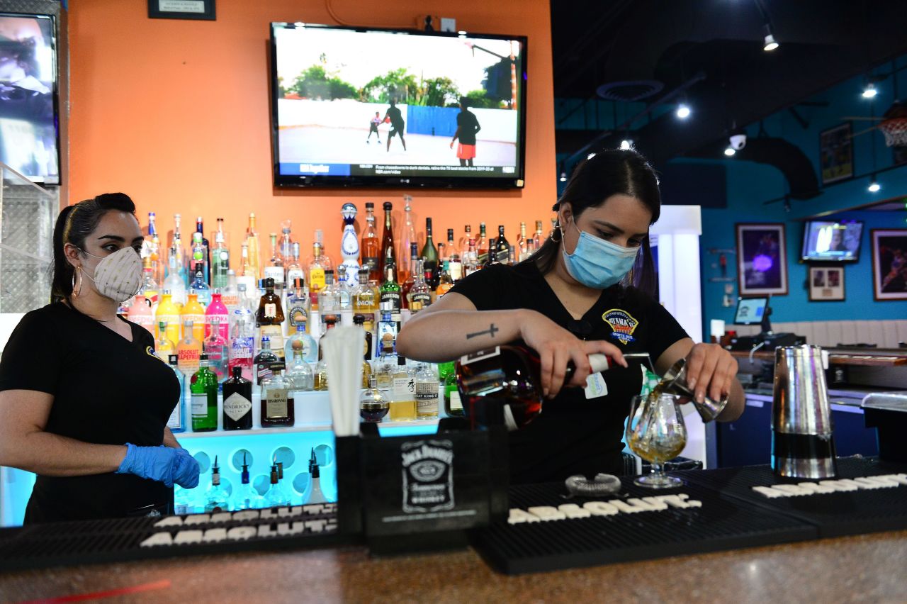 Bartenders prepare a drink for a customer at Juana's Latin Sports Bar & Grill in Miramar, Florida, on May 18.