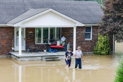 A couple abandons their home flooded by the waters of the North Fork of the Kentucky River in Jackson, Kentucky, on July 28.