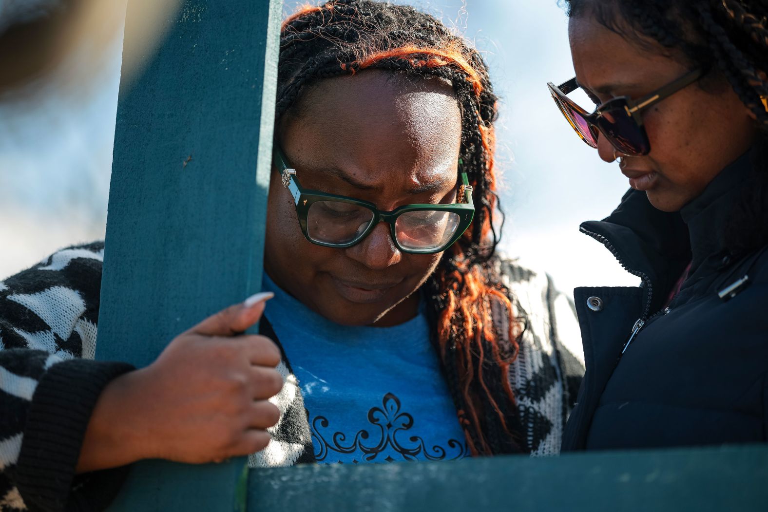 Giselle Emerson prays at a memorial site near the airport on Saturday.