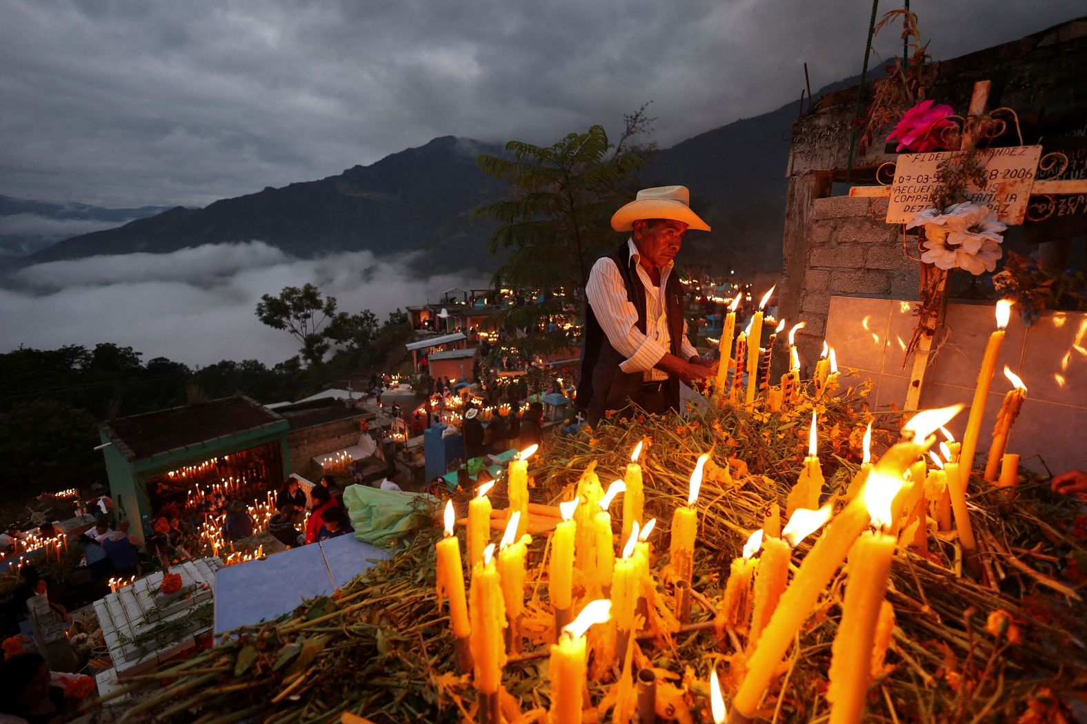 A man lights candles during <a href="index.php?page=&url=https%3A%2F%2Fwww.cnn.com%2Ftravel%2Fday-of-the-dead-traditions-explained-cec%2Findex.html">Day of the Dead</a> celebrations in Mazatlán Villa de Flores, Mexico, on Saturday, November 2.