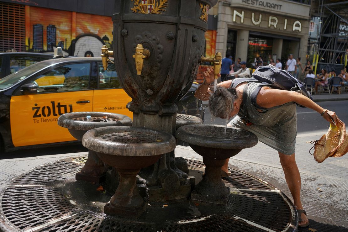 A tourist cooling down in a fountain amid a heatwave in Barcelona, Spain, on July 19, 2023.