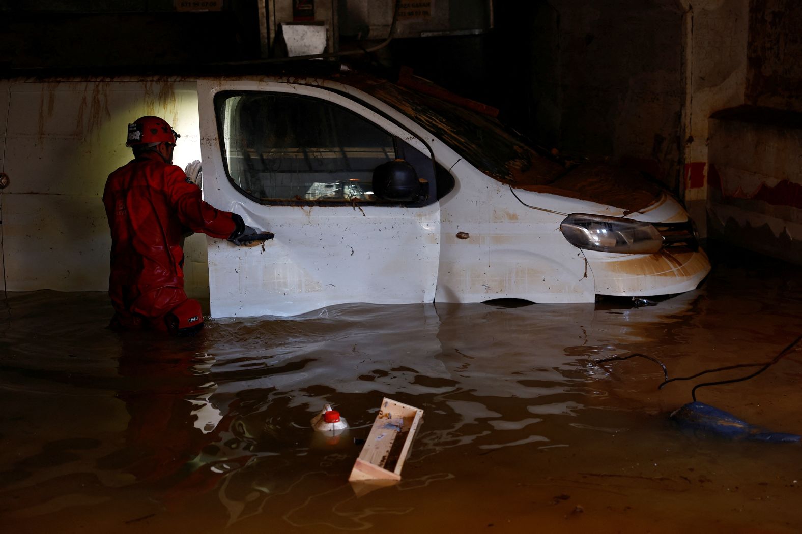 A firefighter checks inside a vehicle at a flooded garage in Alfafar on Saturday.