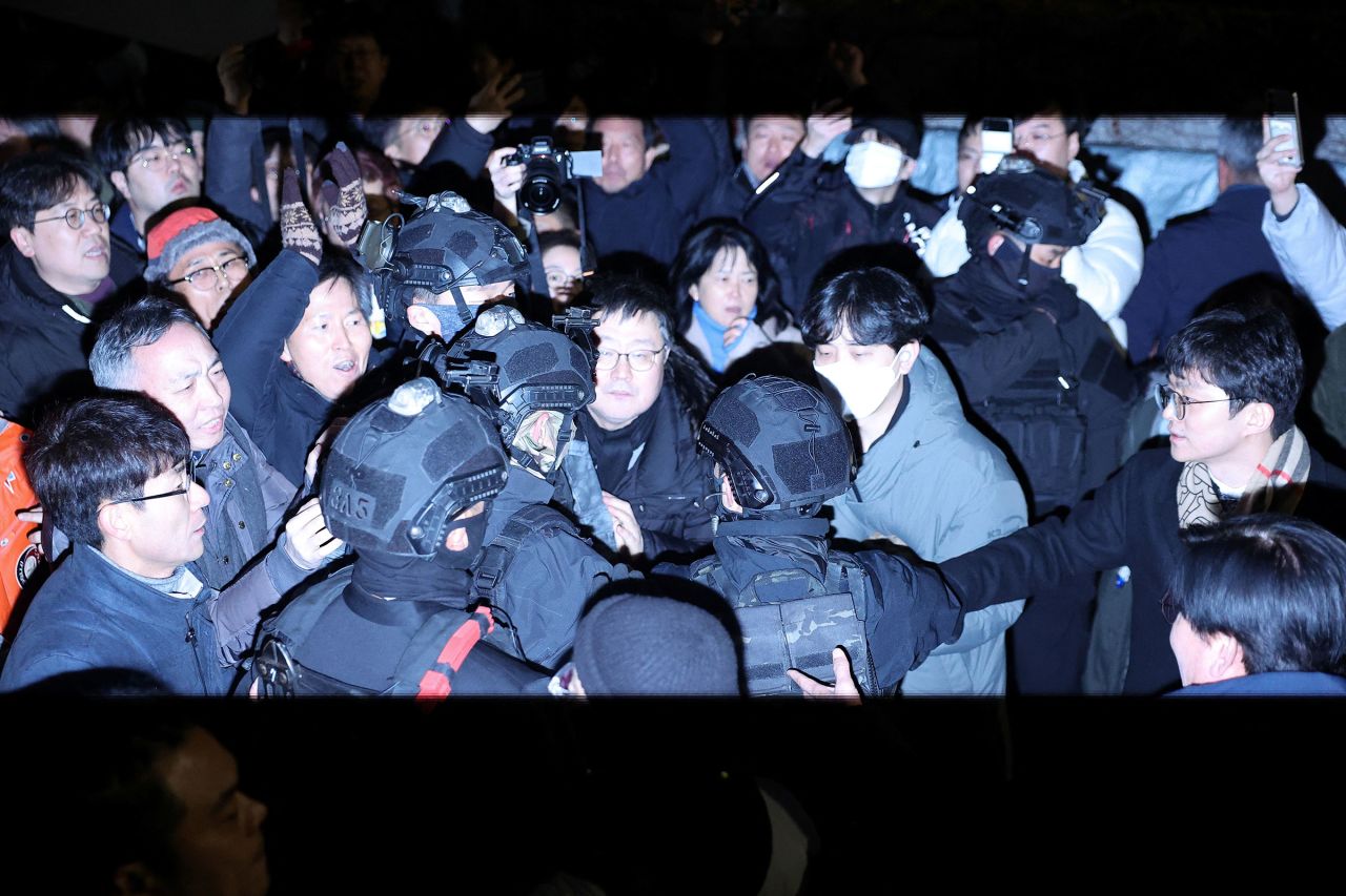 Members of the military make their way through the crowd in front of the National Assembly.