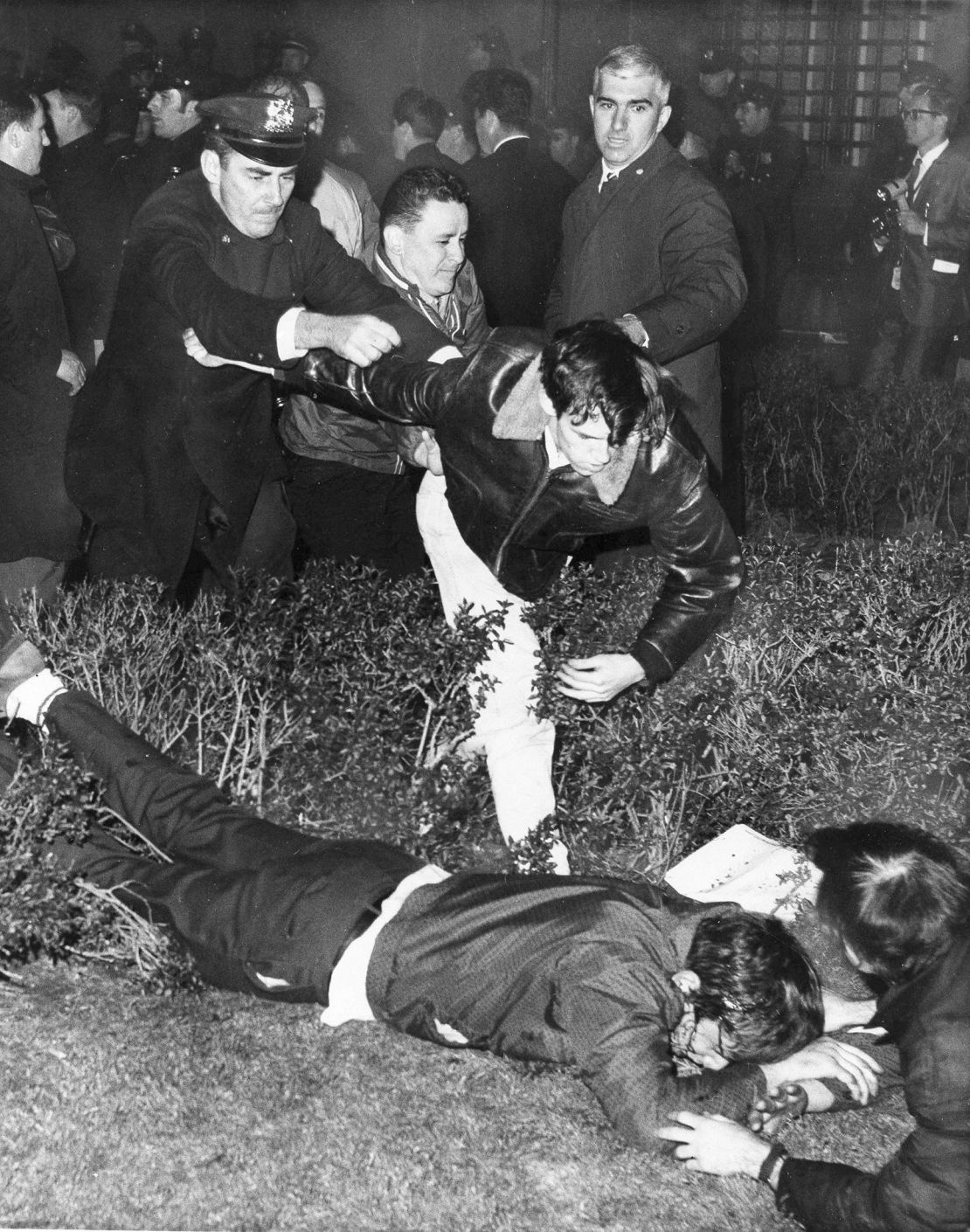 Police grab a youth as he tries to help a wounded man lying on the ground, after students holding a sit-in at Columbia University buildings were removed on April 30, 1968.