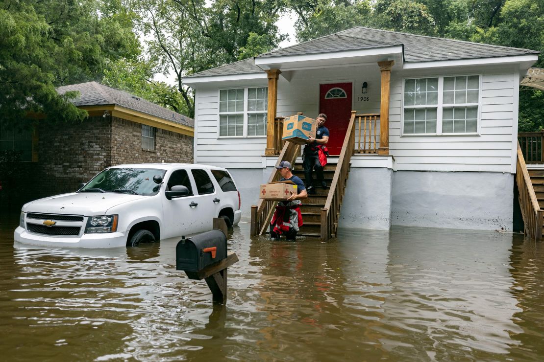 First responders in Savannah, Georgia, carry food Tuesday to residents that were stranded in stormwater from Tropical Storm Debby.