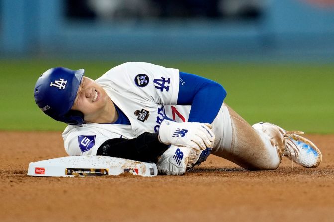 Los Angeles Dodgers' Shohei Ohtani holds his arm after <a href="https://www.cnn.com/2024/10/26/sport/la-dodgers-shohei-ohtani-world-series-injury/index.html">suffering an injury</a>  while trying to steal second base during the seventh inning. Ohtani eventually walked off the field with trainers holding his left arm.