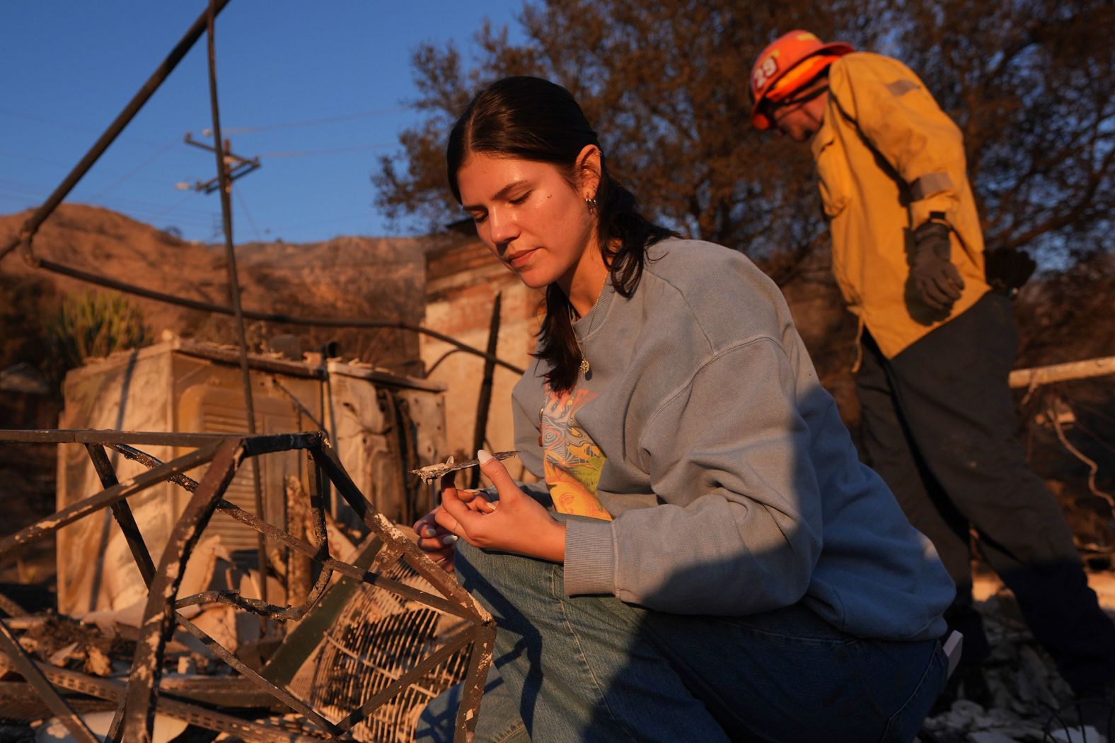 Ella Venne searches through the remnants of her family's home in Altadena after it was destroyed by the Eaton Fire.