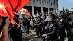La policía de Los Ángeles, con equipo antidisturbios, forma una línea de escaramuza y hace retroceder a los manifestantes por una calle, lejos de un edificio federal en el centro de Los Ángeles, el 9 de junio.