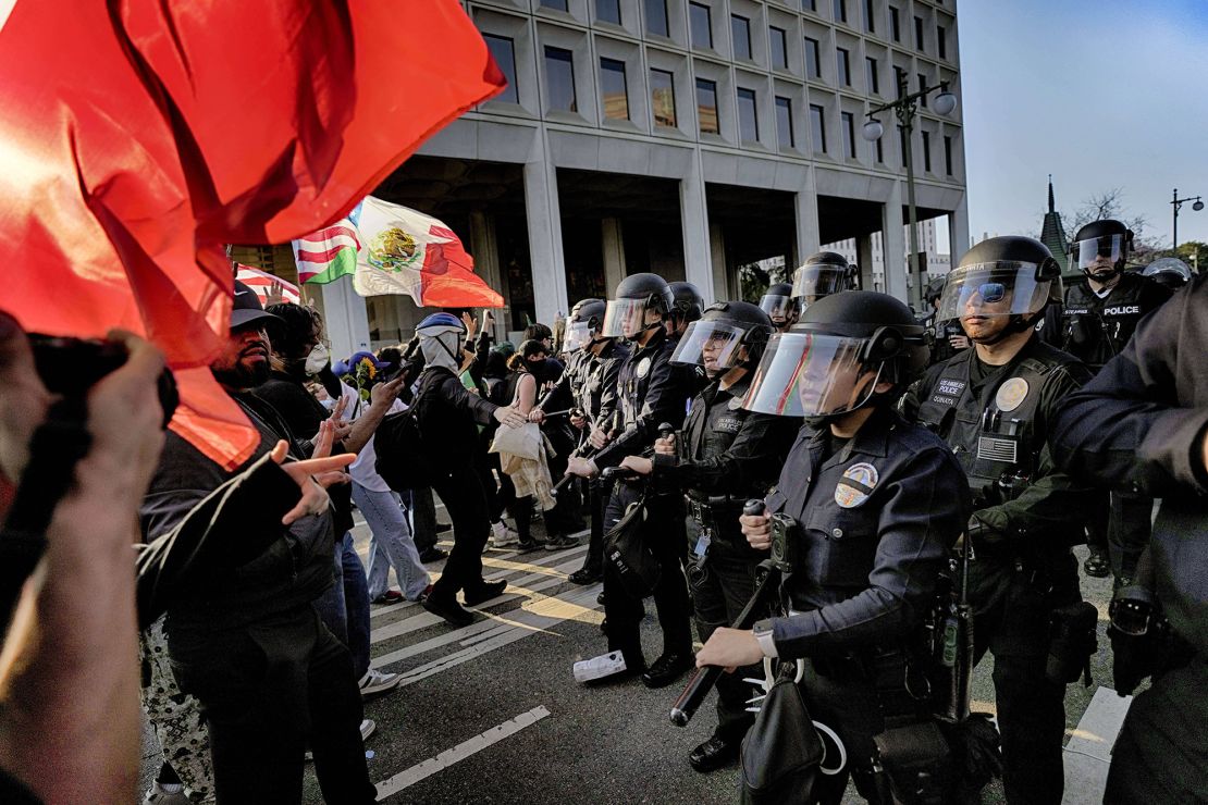 Los Angeles police in riot gear form a skirmish line and push protesters away from a federal building in downtown Los Angeles on June 9.