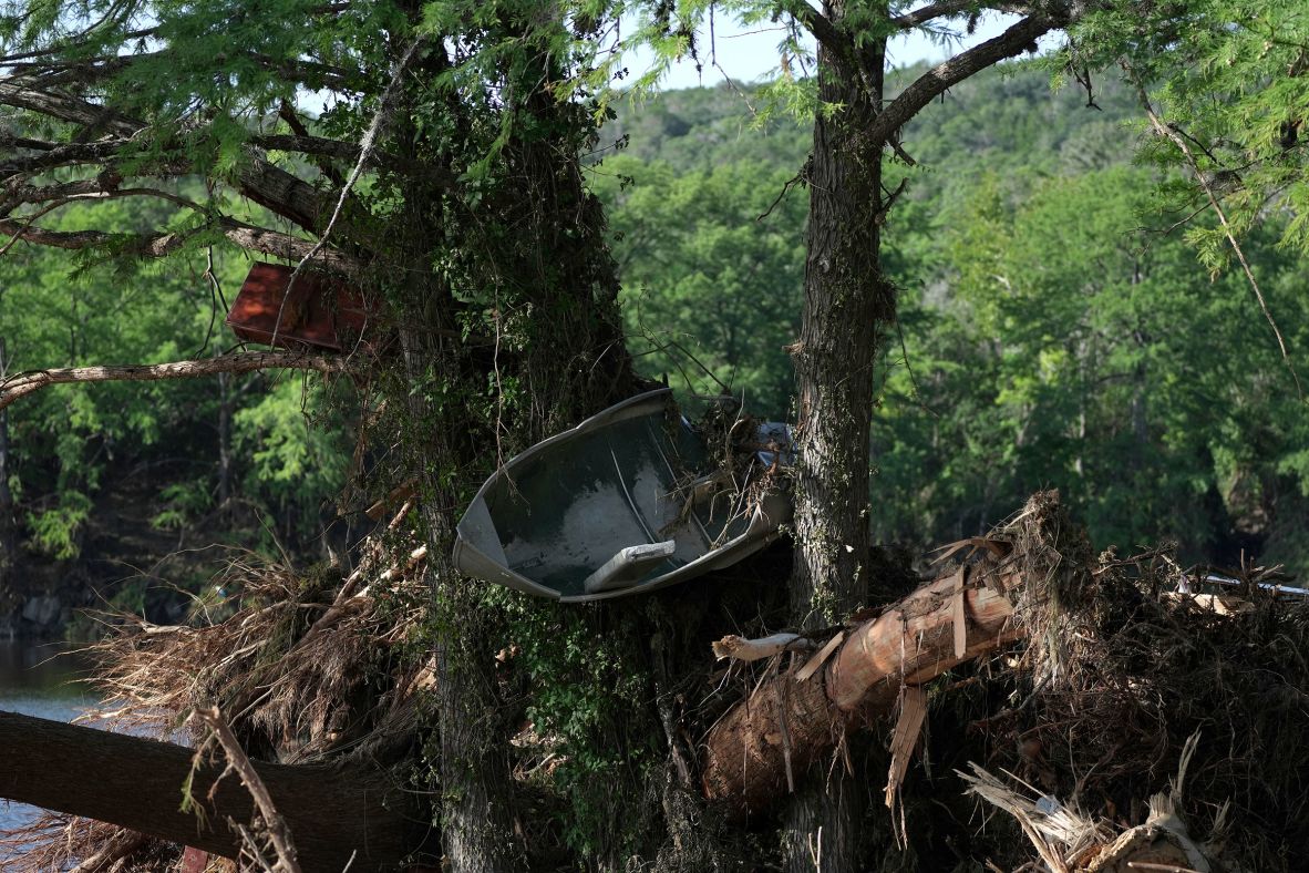 A boat and other debris are seen stuck in damaged trees in Ingram, Texas, on Thursday.