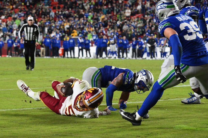 Washington Commanders quarterback Jayden Daniels suffered an arm injury as he is tackled by Seattle Seahawks linebacker Drake Thomas in the second half Sunday.
