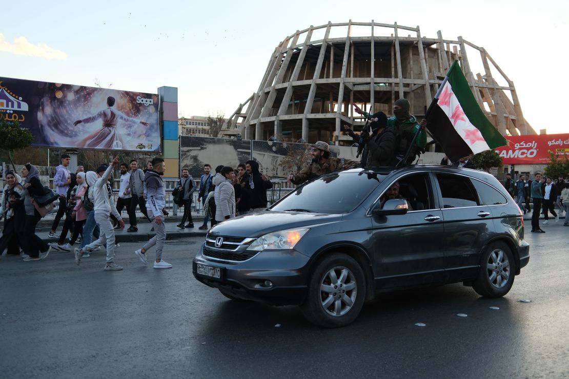 A group of rebels drives by the celebrations in Damascus.