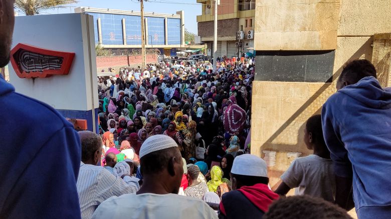 People from states of Khartoum and al-Jazira, displaced by the ongoing conflict in Sudan between the army and paramilitaries, queue to receive aid from a charity organisation in Gedaref on December 30, 2023.