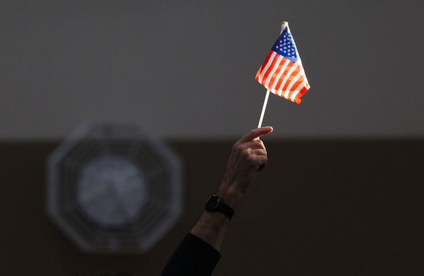An election worker raises a flag while assisting voters at a polling station in Las Vegas on November 5, 2024.