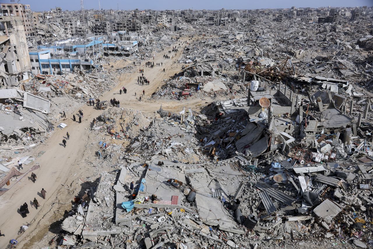 People walk towards their homes through the destroyed streets of Gaza City on Sunday.