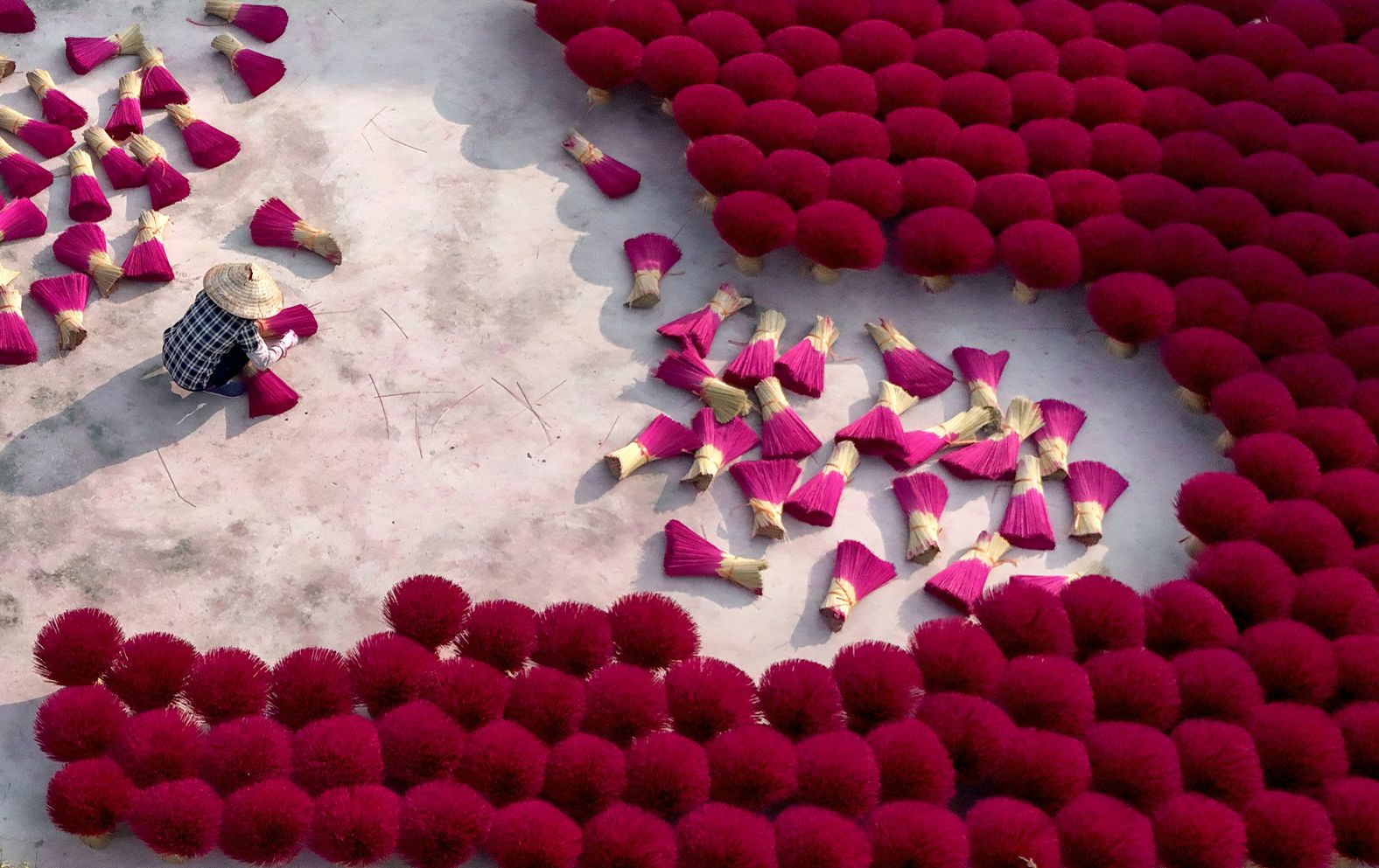 A worker arranges incense sticks to dry in a courtyard in Quảng Phú Cầu, a Vietnamese village on the outskirts of Hanoi, on Tuesday, January 21. The Lunar New Year begins on January 29.
