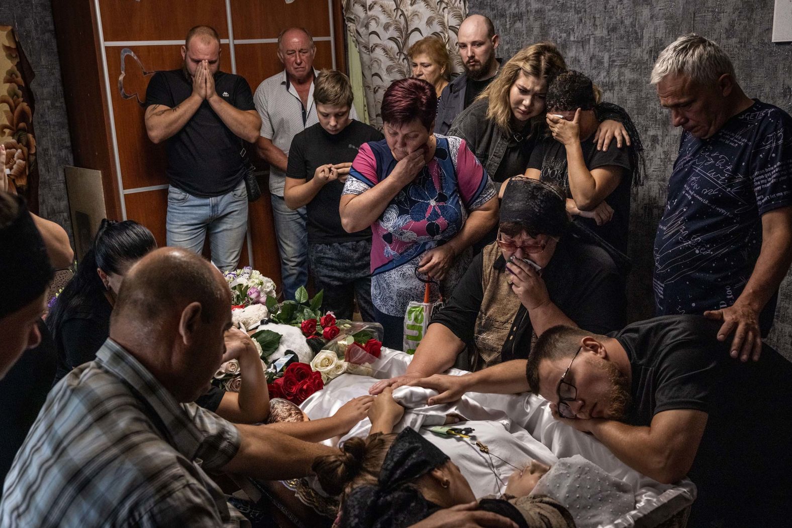 Friends and family members mourn over the body of Diana Koskyk before a funeral for her and her unborn baby Damir at her home in Kamianske, Ukraine, on Thursday, July 31. Koskyk was killed in a missile strike that damaged a maternity hospital where she was receiving treatment.