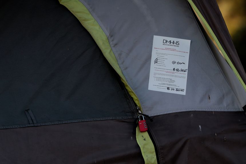 A note detailing a scheduled encampment cleanup from the Office of the Deputy Mayor for Health and Human Services is posted on a tent near Washington Circle in Washington, DC, on August 14.